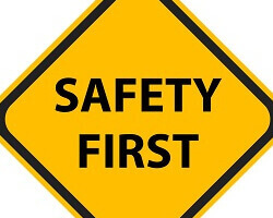 A yellow diamond-shaped street sign that says "safety first."