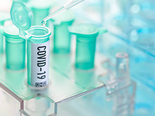 Closeup of test tubes and a dropper for COVID lab work.